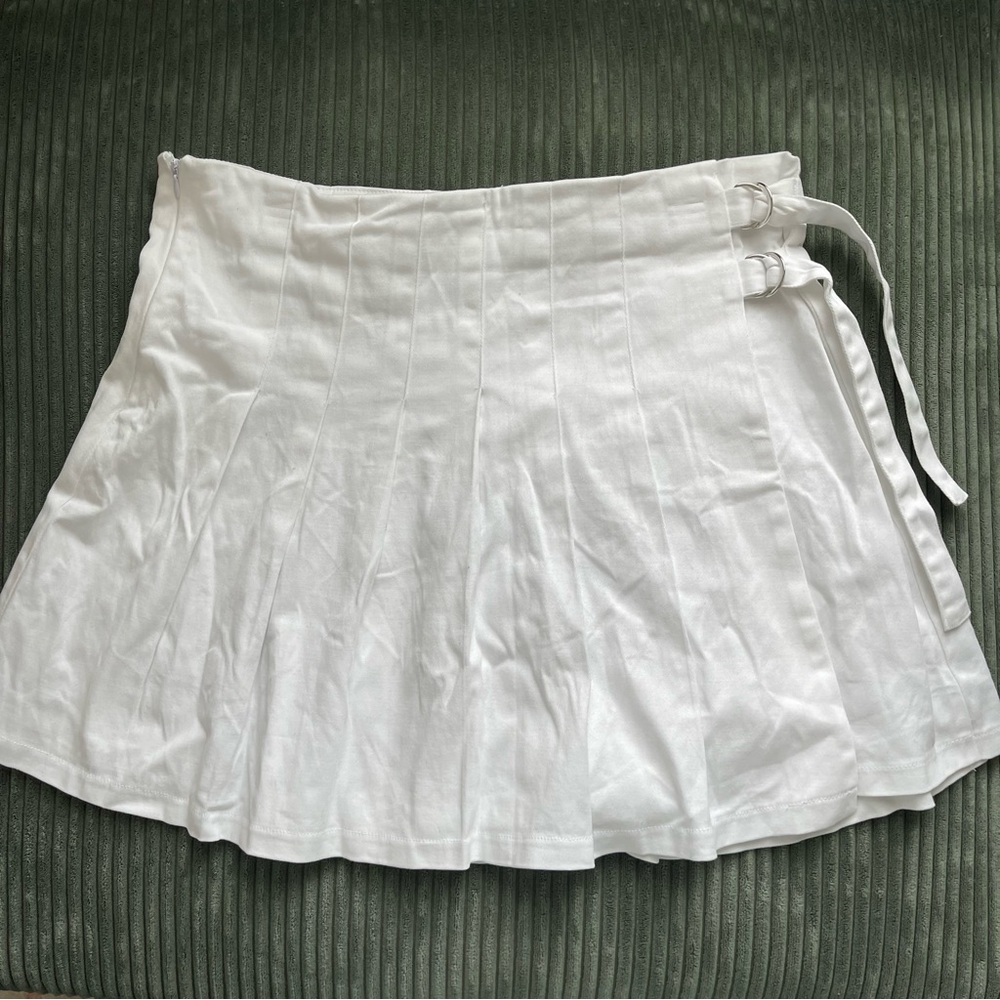 Pleated white mini skirt with tightening buckles on side